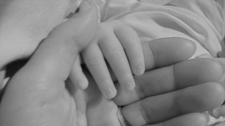 Baby holding mothers hand