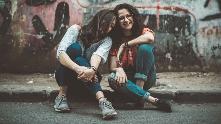 Girls sitting on sidewalk