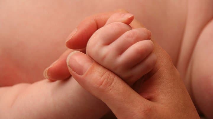 Mother holding baby's hand