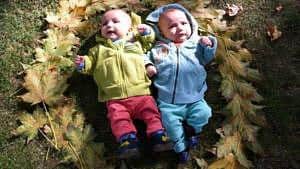 twin baby boys laying outside on ground