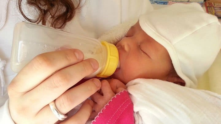 Woman bottle feeding baby